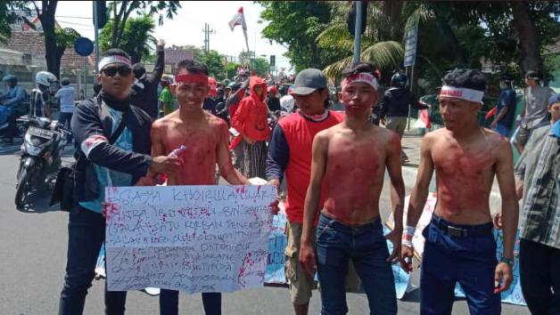 Salah satu peserta demonstran melaburi tubuhnya dengan cat berwarna merah sebagai simbol perlawanan mereka terhadap ketidakadilan