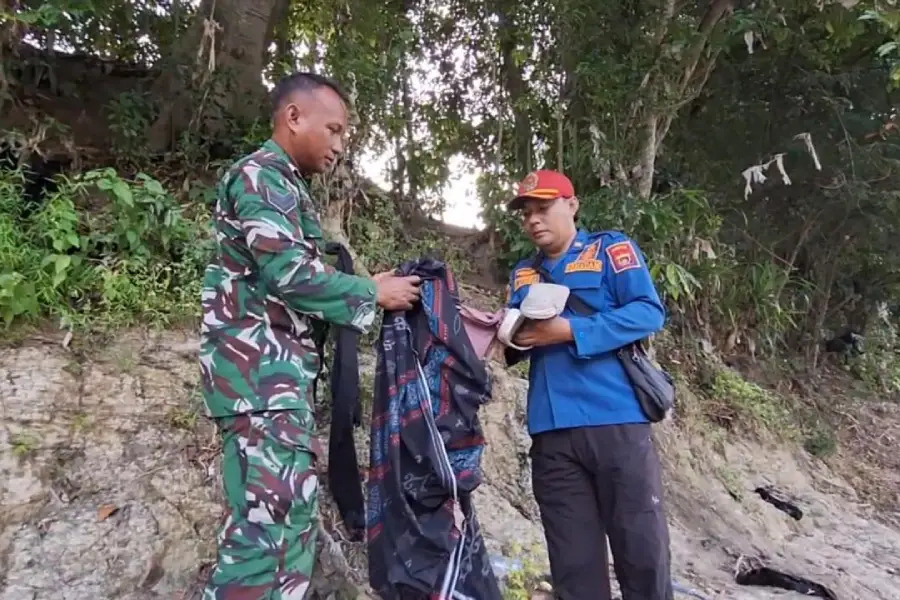 Petugas menunjukkan barang-barang berupa pakaian milik santri Pondok Pesantren Miftahul Jannah yang diduga tenggelam di Bengawan Solo